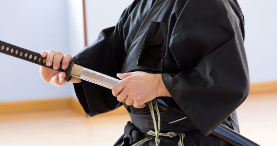 Eine Männerhand zieht ein japanisches Katana