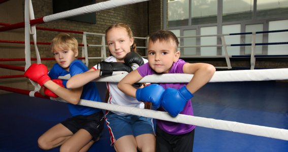 Drei Kinder tragen Boxhandschuhe