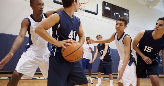Jugendliche spielen Basketball in der Halle