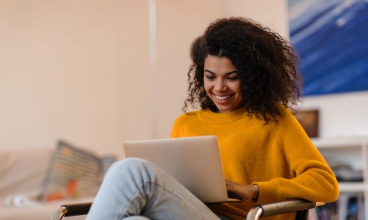 Frau lacht vor Laptop