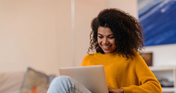 Frau lacht vor Laptop