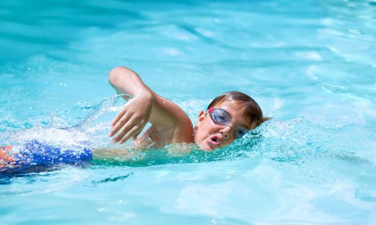 Junge lernt Kraulschwimmen im Schwimmunterricht