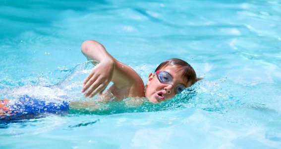 Junge lernt Kraulschwimmen im Schwimmunterricht