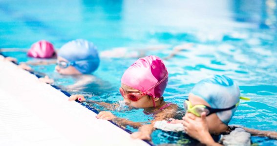 Kinder im Becken lernen schwimmen
