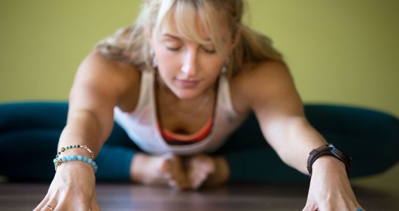 Frau macht Yin Yoga mit geschlossenen Augen