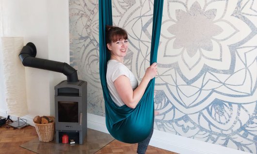 Frau sitzt im Yogatuch