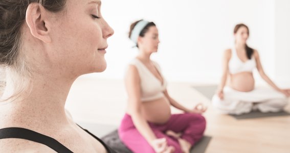 Schwangere Frauen meditieren beim Pilates