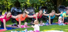 Mamas machen Fitnessübungen im Park, die Kinder spielen