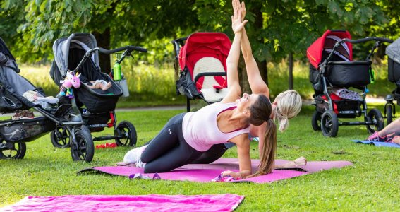 Zwei Mamas machen eine Fitnessübung gemeinsam