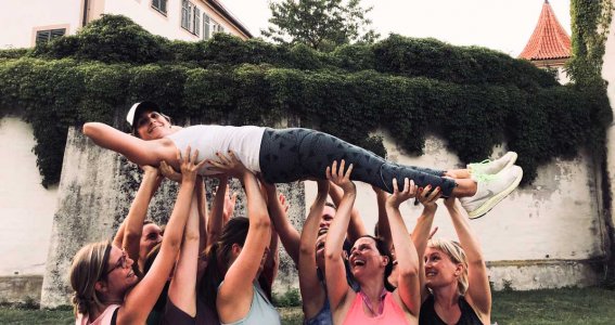 Workout Frauen heben ihre Trainerin hoch
