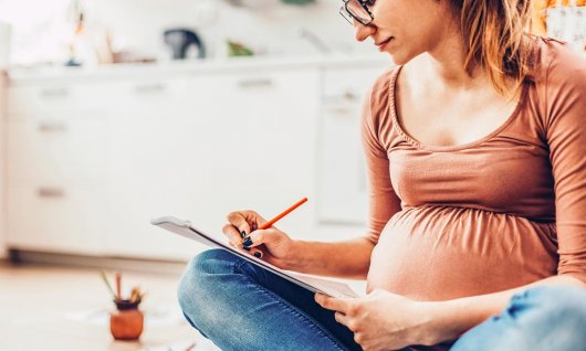 Frau notiert sich Tipps für das richtige Stillen