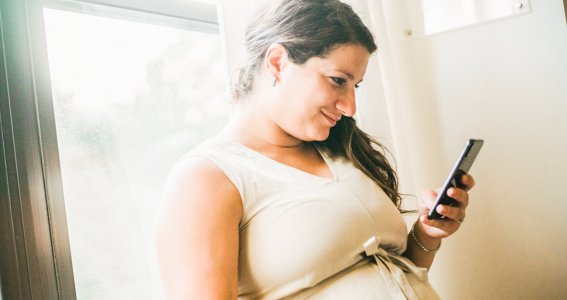 Schwangere Frau am Handy