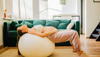 Schwangere Frau auf einem Gymnastikball