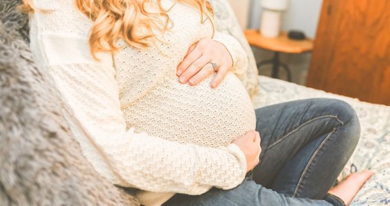 Schwangere Frau hält ihren Bauch