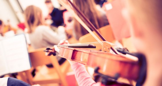 Kinder lernen Geige im Musikunterricht