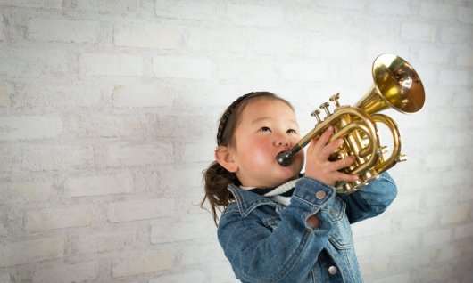 Trompete spielen im Musikunterricht in München Kleines Mädchen spielt Trompete