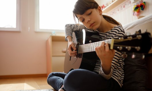 Gitarrenunterricht E-Gitarre für Kinder in München Mädchen übt für den Musikunterricht