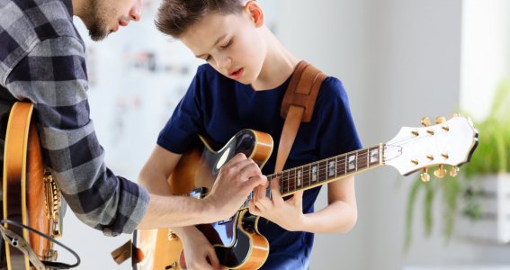 Junge bekommt Gitarrenunterricht
