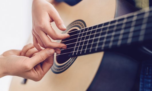 Gitarre spielen lernen für Kinder in München Gitarrenlehrerin bringt einen Gitarrengriff bei