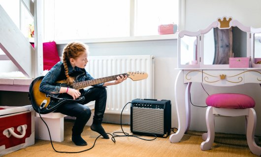 Elektrische Gitarre lernen für Kinder in München Mädchen übt für den E-Gitarrenunterricht