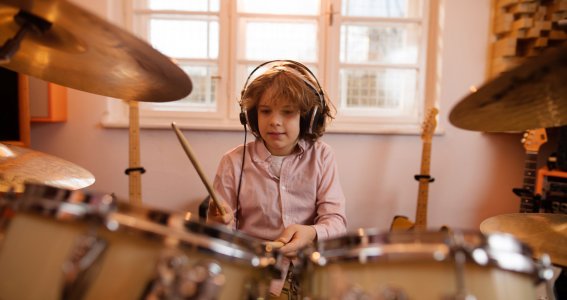 Junge lernt Schlagzeug spielen