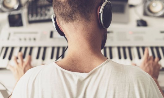 Keyboardunterricht für Erwachsene in München Mann mit Kopfhörern spielt Keyboard