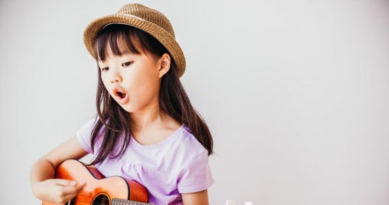 Mädchen begleitet sich beim Singen mit einer Ukulele