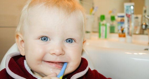 Baby mit Zahnbürste im Mund