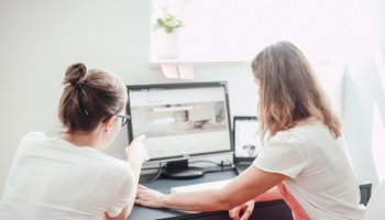 2 Frauen blicken Richtung Monitor