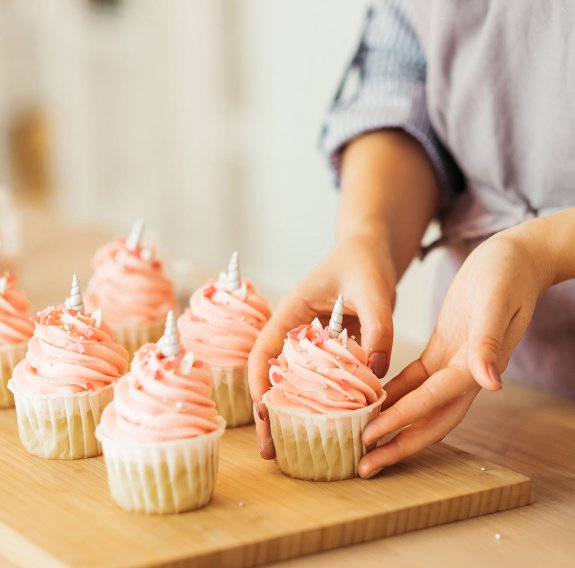 Ein Backblech mit rosafarbenen Cupcakes 