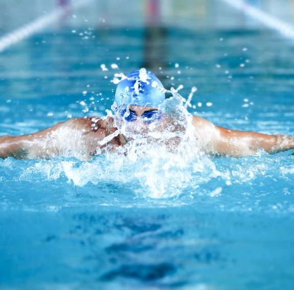 Ein Mann mit einer Schwimmbrillle ist am schwimmen
