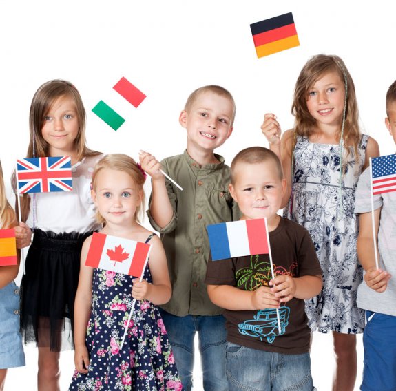 Eine Gruppe von Kindern hält Fahnen unterschiedlicher Länder hoch