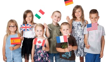 Eine Gruppe von Kindern hält Fahnen unterschiedlicher Länder hoch
