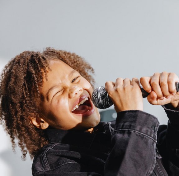 Ein Junge singt ins Mikrofon