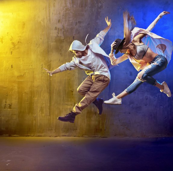 Zwei junge Tänzer in cooler Kleidung posieren im Sprung