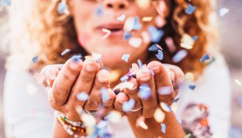 Frau die Konfetti pustet