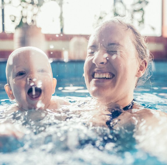 Baby mit Mama im Schwimmkurs