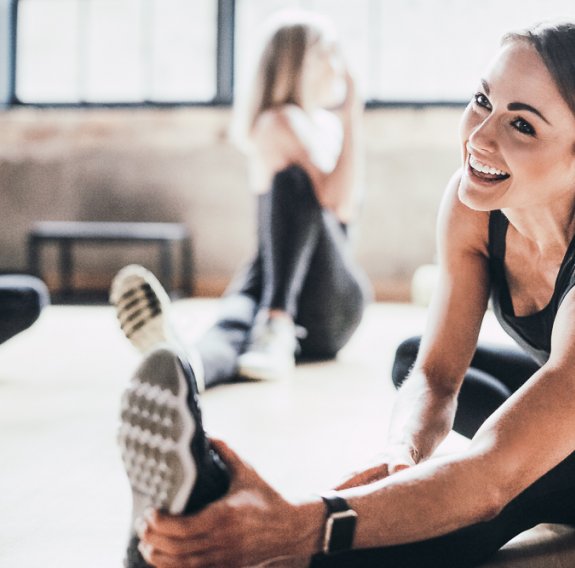 Frau die im Sportkurs sich dehnt