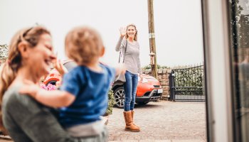 Mama die sich von ihrem Kind verabschiedet bevor sie zum Kurs geht