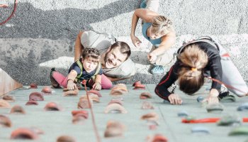 Familie die am Klettergerüst Sport ausübt