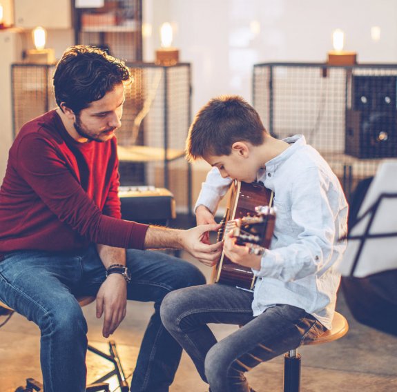 Kind im Gitarrenunterricht